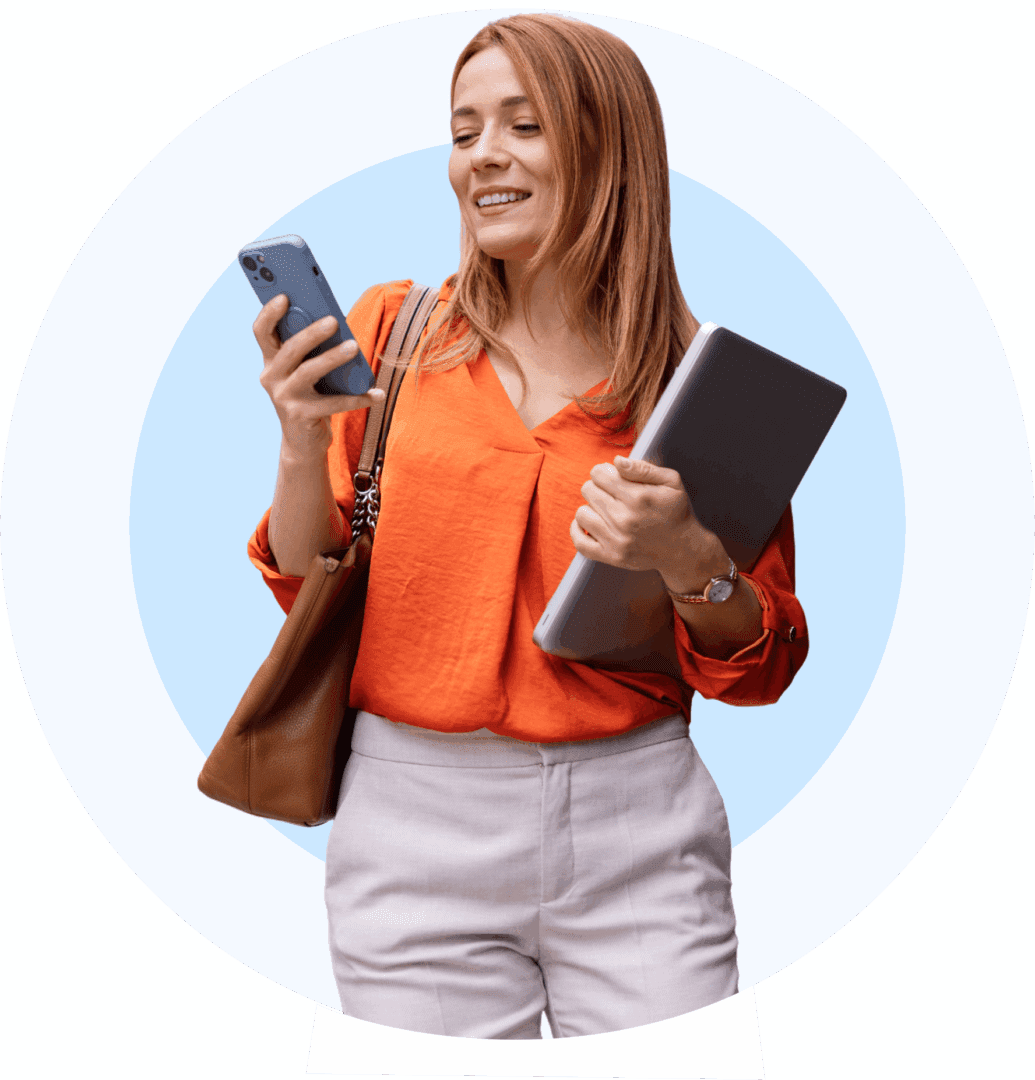 Smiling woman in orange blouse holding a notebook and phone.