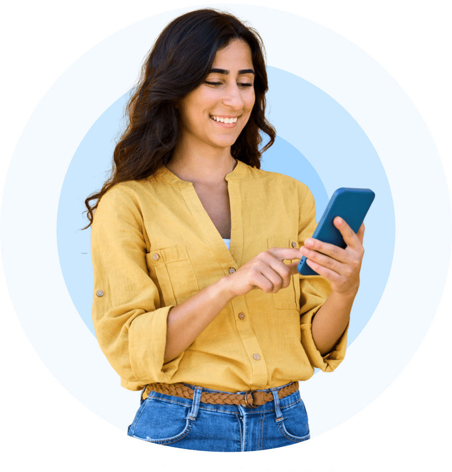 A woman smiling while using her smartphone.